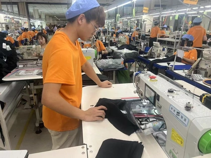 Operator sewing garments on the production line