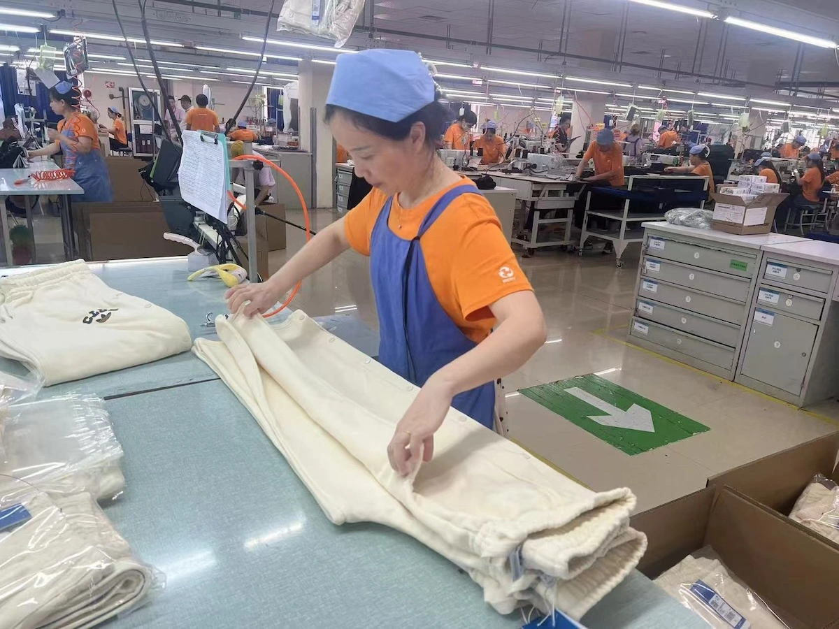 Garment Quality Control Inspection Quality control worker checking garment measurements against a written specification