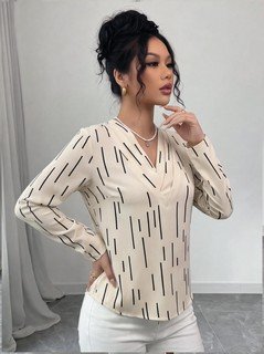 Front close up of the ivory abstract-dash print v-neck long-sleeve blouse, showing abstract dash print, v-neckline and long sleeves.