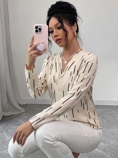 Seated front view of the ivory abstract-dash print v-neck long-sleeve blouse, showing the silhouette and fit.