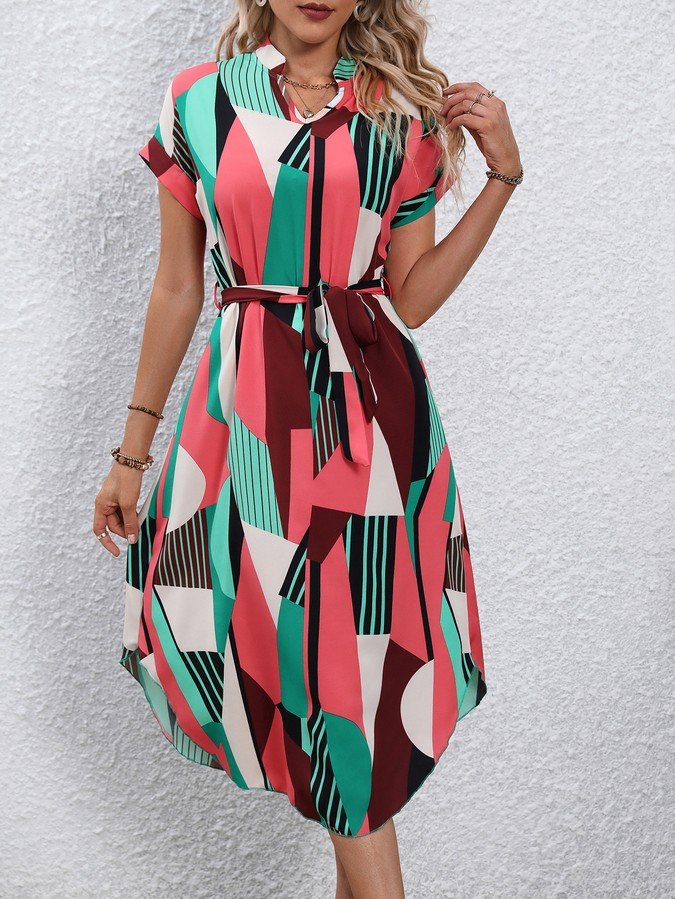 Front view of the pink and green abstract geometric shirt dress, showing its silhouette and design details.