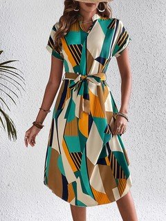 Angled front view of the teal and yellow abstract geometric shirt dress, showing its silhouette and design details.