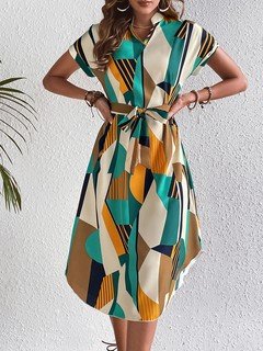 Styled front view of the teal and yellow abstract geometric shirt dress, showing its silhouette and design details.