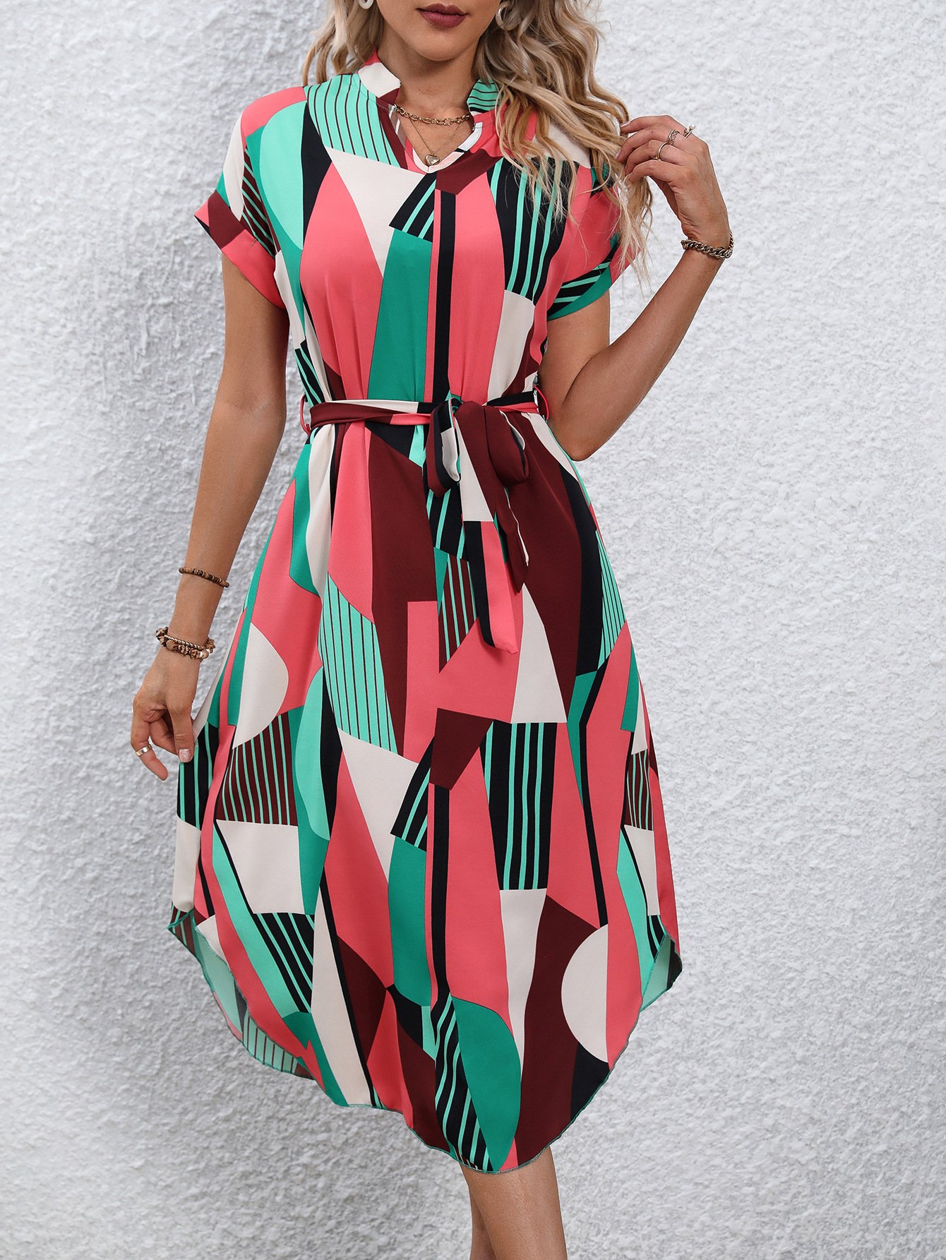 Front view of the pink and green abstract geometric shirt dress, showing its silhouette and design details.