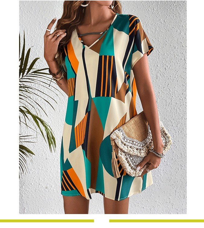 Angled front view of the teal and yellow geometric v-neck shift dress, showing its silhouette and design details.