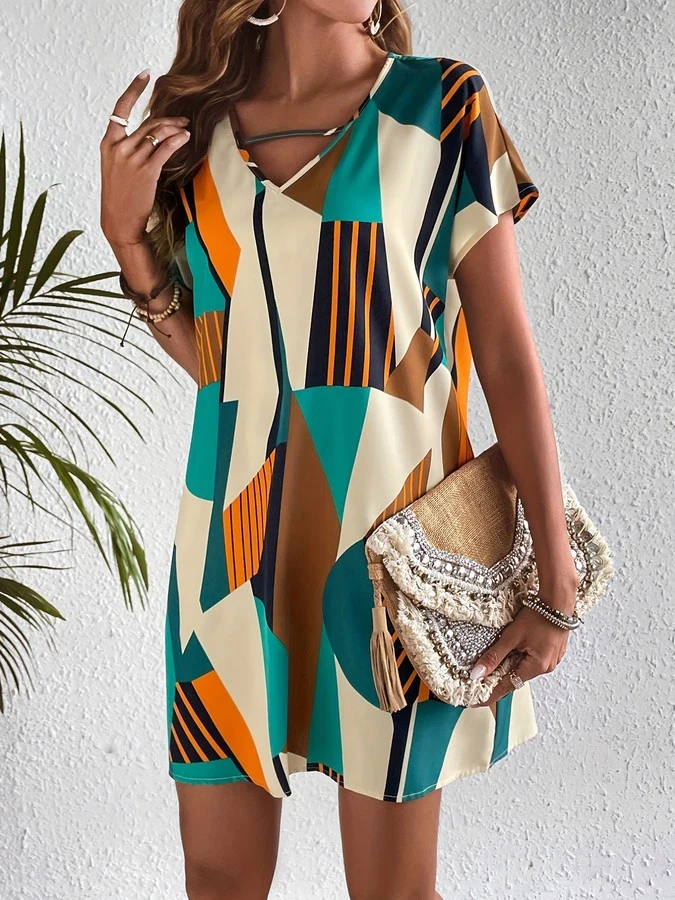 Lifestyle front view of the teal and yellow geometric v-neck shift dress, showing its silhouette and design details.