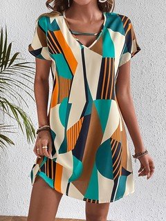 Front design view of the teal and yellow geometric v-neck shift dress, showing its silhouette and design details.