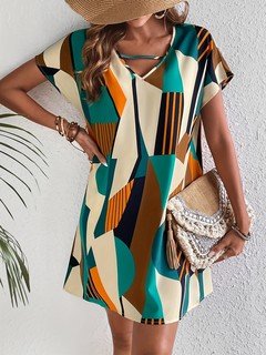 Full-length front view of the teal and yellow geometric v-neck shift dress, showing its silhouette and design details.