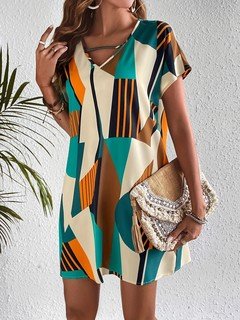 Lifestyle front view of the teal and yellow geometric v-neck shift dress, showing its silhouette and design details.
