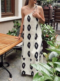 Lifestyle front view of the cream and black abstract one-shoulder shift dress, showing its silhouette and design details.