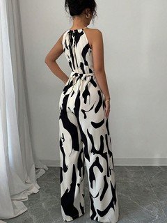 Back view of the black and white abstract halter wide-leg jumpsuit, showing its silhouette and design details.