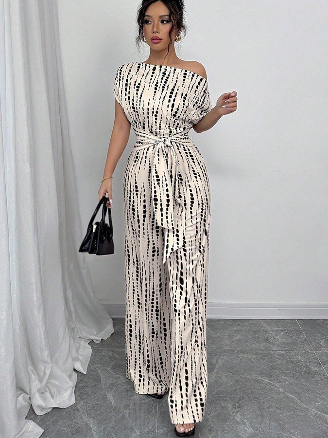 Angled front view of the cream and black striped one-shoulder jumpsuit, showing its silhouette and design details.