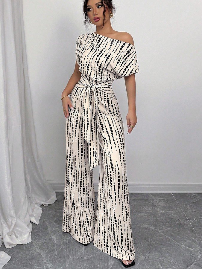 Front view of the cream and black striped one-shoulder jumpsuit, showing its silhouette and design details.