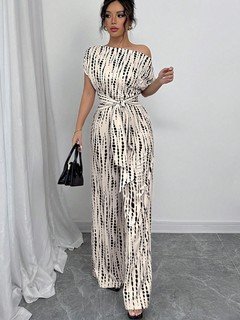 Angled front view of the cream and black striped one-shoulder jumpsuit, showing its silhouette and design details.