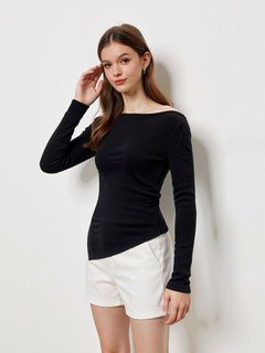 Lifestyle front view of the black asymmetric boat-neck ruched top, showing its silhouette and design details.