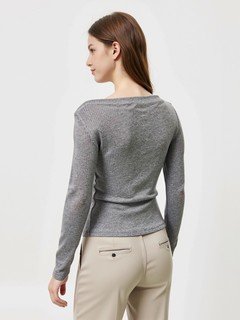 Lifestyle front view of the gray asymmetric boat-neck ruched top, showing its silhouette and design details.