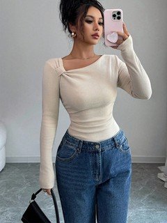 Lifestyle front view of the ivory asymmetric draped-neck top, showing its silhouette and design details.