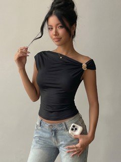 Full-length front view of the black hardware-detail off-shoulder top, showing its silhouette and design details.