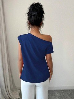 Back view of the blue asymmetric one-shoulder draped sleeveless top, showing the silhouette and fit.