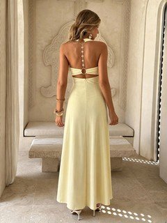 Back view of the yellow backless cross-strap halter maxi dress, showing the silhouette and fit.