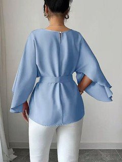 Back view of the light blue belted bell-sleeve blouse, showing its silhouette and design details.