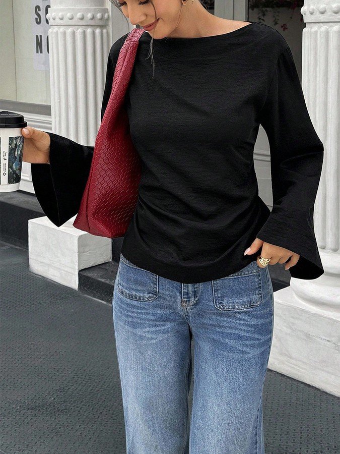 Angled front view of the black boat-neck bell-sleeve blouse, showing its silhouette and design details.