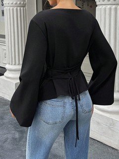 Back view of the black boat-neck bell-sleeve blouse, showing its silhouette and design details.
