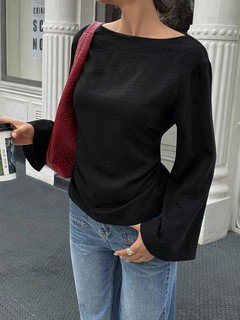 Full-length front view of the black boat-neck bell-sleeve blouse, showing its silhouette and design details.