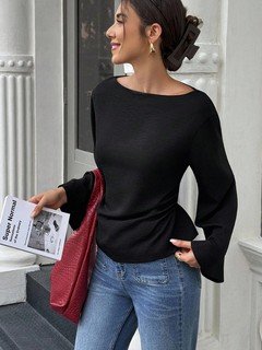 Lifestyle front view of the black boat-neck bell-sleeve blouse, showing its silhouette and design details.