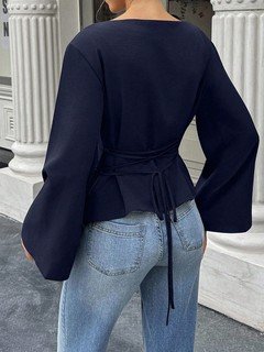Back view of the navy boat-neck bell-sleeve blouse, showing its silhouette and design details.