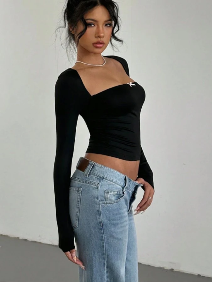 Angled front view of the black bow-detail square-neck top, showing its silhouette and design details.
