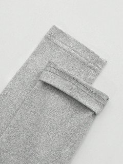 Construction detail of the gray bow-motif long-sleeve ruched top, showing the garment finish.