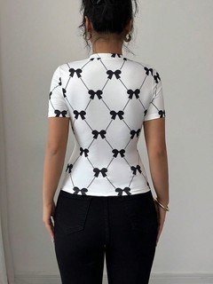 Back view of the white and black bow print short-sleeve top, showing its silhouette and design details.