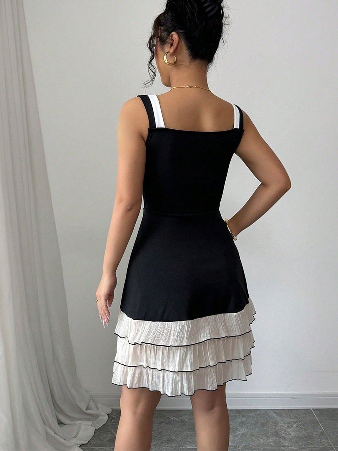 Back view of the black and white bow-strap tiered ruffle dress, showing its silhouette and design details.