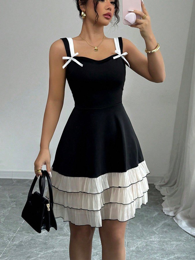 Front view of the black and white bow-strap tiered ruffle dress, showing its silhouette and design details.