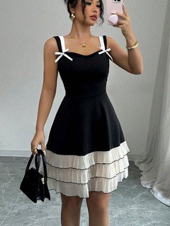 Angled front view of the black and white bow-strap tiered ruffle dress, showing its silhouette and design details.
