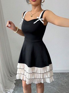 Lifestyle front view of the black and white bow-strap tiered ruffle dress, showing its silhouette and design details.