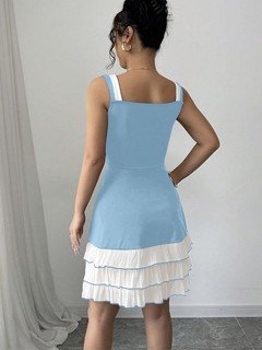 Back view of the blue and white bow-strap tiered ruffle dress, showing its silhouette and design details.