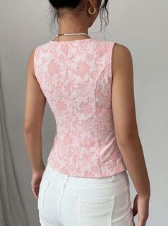 Angled back view of the pink button-front v-neck tailored vest, showing its silhouette and design details.