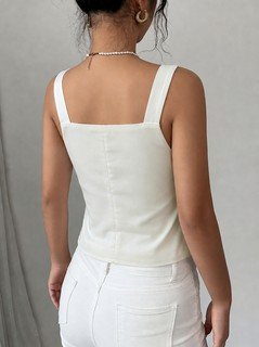 Back view of the white button-front v-neck tailored vest, showing its silhouette and design details.