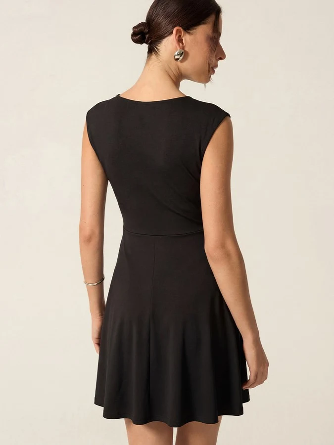 Back view of the black cap-sleeve fit-and-flare dress, showing its silhouette and design details.