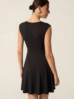 Back view of the black cap-sleeve fit-and-flare dress, showing its silhouette and design details.