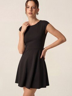 Lifestyle front view of the black cap-sleeve fit-and-flare dress, showing its silhouette and design details.