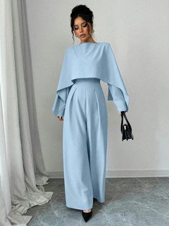 Angled front view of the light blue cape-overlay tie-waist wide-leg jumpsuit, showing the silhouette and fit.