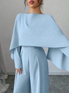 Front close up of the light blue cape-overlay tie-waist wide-leg jumpsuit, showing cape overlay, adjustable waist and wide-leg pants.