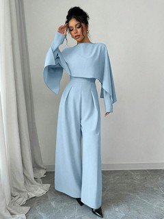 Styled front view of the light blue cape-overlay tie-waist wide-leg jumpsuit, showing the silhouette and fit.