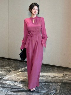 Angled front view of the magenta cape-sleeve tie-waist wide-leg jumpsuit, showing the silhouette and fit.