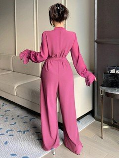Back view of the magenta cape-sleeve tie-waist wide-leg jumpsuit, showing the silhouette and fit.