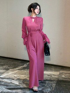 Front close up of the magenta cape-sleeve tie-waist wide-leg jumpsuit, showing flowing cape sleeves, tie waist and wide legs.