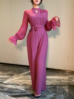 Styled front view of the magenta cape-sleeve tie-waist wide-leg jumpsuit, showing the silhouette and fit.